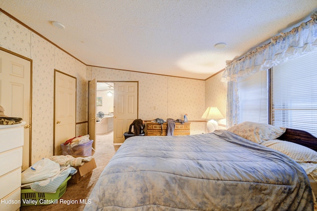 carpeted bedroom with lofted ceiling, a textured ceiling, ornamental molding, and wallpapered walls