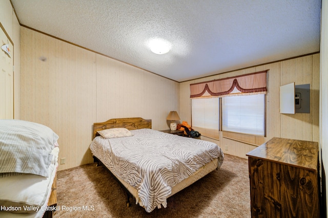 bedroom with wooden walls, a textured ceiling, carpet flooring, and crown molding