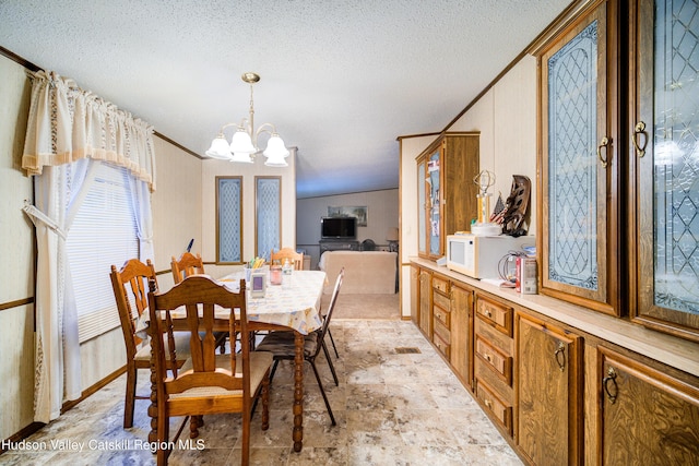 dining area with an inviting chandelier, crown molding, and a textured ceiling