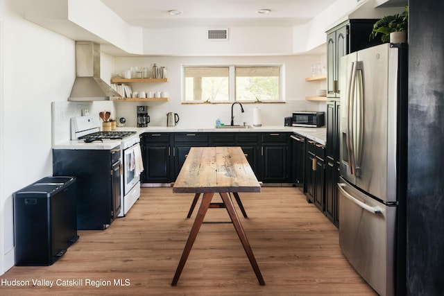 394 Macmore Rd, Roxbury, NY 12474 - kitchen with stainless steel refrigerator with ice dispenser, white range with gas stovetop, open shelves, wall chimney range hood, and light wood finished floors
