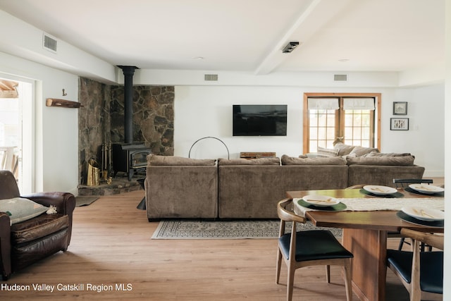 394 Macmore Rd, Roxbury, NY 12474 - living area featuring light wood finished floors, beam ceiling, and a wood stove