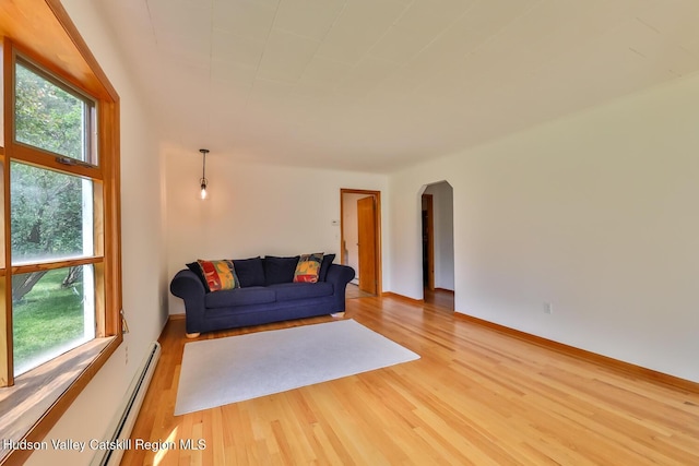 18 Maplewood Ave, Windham, NY 12496 - living area with arched walkways, wood finished floors, and a baseboard radiator