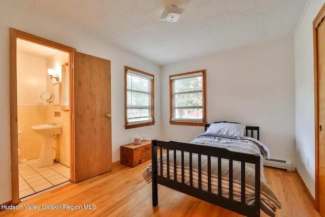18 Maplewood Ave, Windham, NY 12496 - bedroom with baseboard heating, light wood-style floors, and ensuite bath