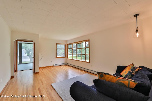 18 Maplewood Ave, Windham, NY 12496 - living area with healthy amount of natural light, light wood-style floors, a baseboard heating unit, and arched walkways