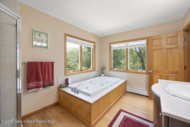 1024 Lakeview Rd, Copake, NY 12516 - bathroom with a baseboard heating unit, wood finished floors, vanity, and a jetted tub