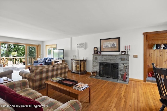 1024 Lakeview Rd, Copake, NY 12516 - living area with a wall mounted AC, light wood-style floors, and a stone fireplace