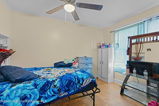 bedroom with light parquet floors, ceiling fan, and ornamental molding