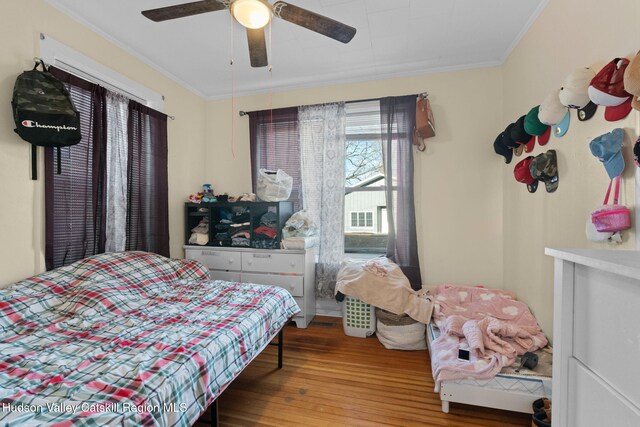 bedroom with wood-type flooring, ceiling fan, and crown molding