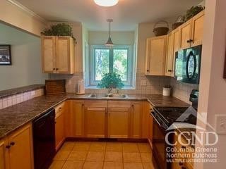 274 Brooksburgh Rd Unit 41, Windham, NY 12496 - kitchen featuring black appliances, tasteful backsplash, a peninsula, light tile patterned flooring, and a sink