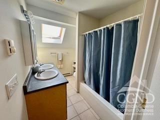 274 Brooksburgh Rd Unit 41, Windham, NY 12496 - bathroom featuring a shower with curtain, tile patterned floors, double vanity, and a skylight