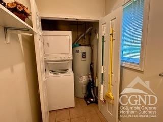 274 Brooksburgh Rd Unit 41, Windham, NY 12496 - clothes washing area featuring estacked washer and dryer, electric water heater, and tile patterned floors