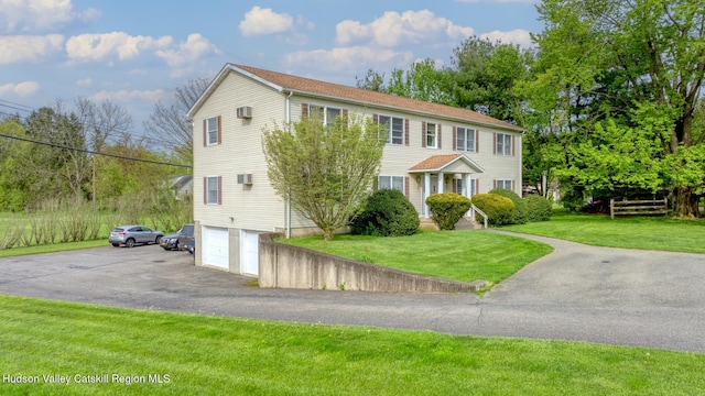 colonial inspired home featuring a front lawn and a garage