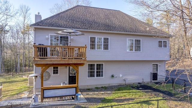 rear view of house with a wooden deck and a yard