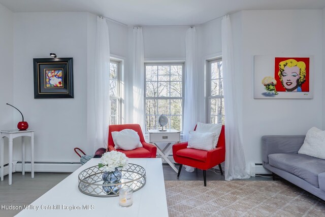 living area featuring wood-type flooring and a baseboard heating unit