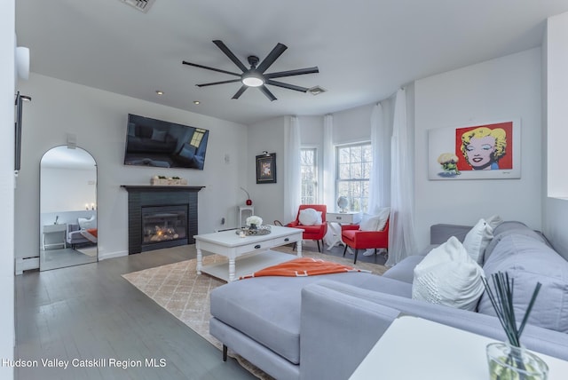 living room with ceiling fan, a baseboard radiator, and dark hardwood / wood-style floors