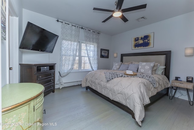 bedroom featuring hardwood / wood-style flooring, a baseboard radiator, and ceiling fan