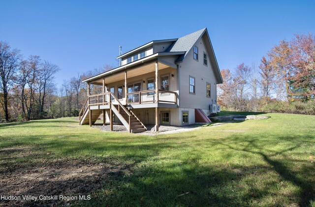 back of house with a wooden deck and a lawn