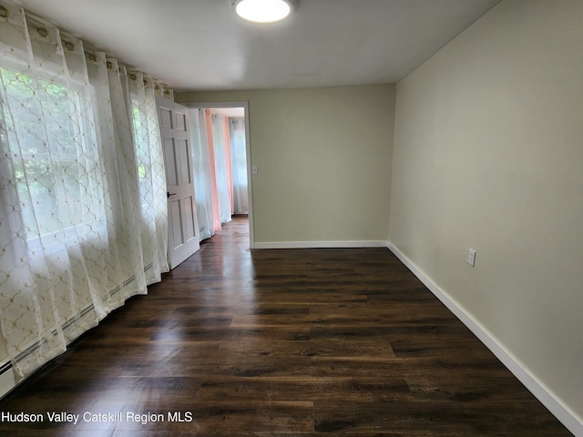 spare room with dark wood-type flooring