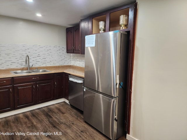 kitchen with sink, dark hardwood / wood-style floors, decorative backsplash, dark brown cabinets, and appliances with stainless steel finishes