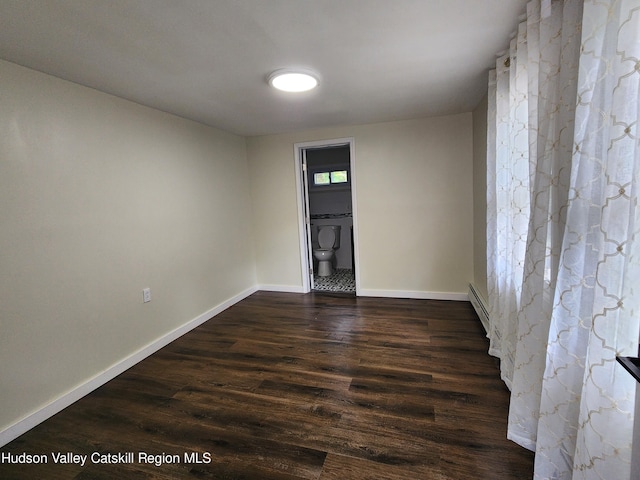 unfurnished room featuring dark hardwood / wood-style floors and a baseboard radiator