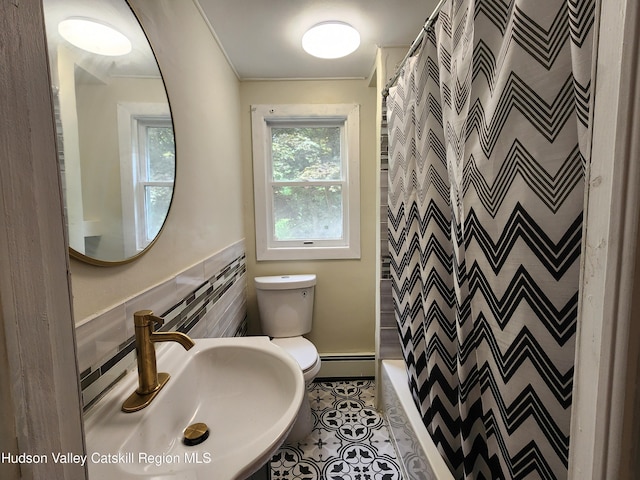 bathroom featuring sink, baseboard heating, tile patterned flooring, crown molding, and toilet