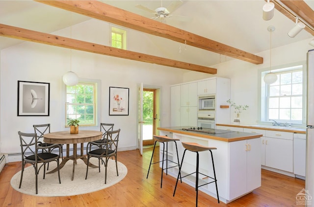 75 Allhusen Rd, Plattekill, NY 12561 - kitchen with a sink, a center island, white cabinetry, a kitchen breakfast bar, and white appliances