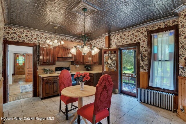 4930 State Route 81, Greenville, NY 12083 - dining space featuring radiator heating unit, an ornate ceiling, a chandelier, wainscoting, and light tile patterned floors