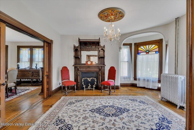 4930 State Route 81, Greenville, NY 12083 - sitting room featuring radiator, arched walkways, wood finished floors, a chandelier, and baseboards