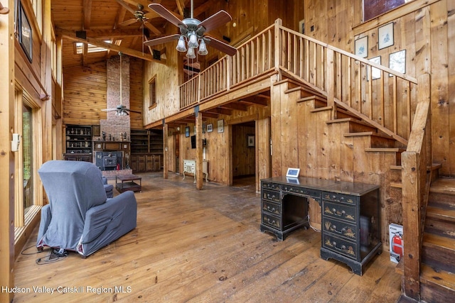 340 Lower Cady Rd, Old Chatham, NY 12136 - living room with a towering ceiling, wood walls, wood-type flooring, a ceiling fan, and stairway