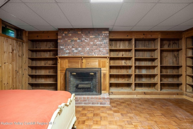 340 Lower Cady Rd, Old Chatham, NY 12136 - unfurnished living room featuring wood walls, a brick fireplace, and a drop ceiling