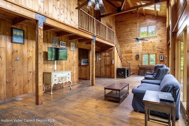 340 Lower Cady Rd, Old Chatham, NY 12136 - living room with ceiling fan, high vaulted ceiling, wood walls, stairs, and hardwood / wood-style floors