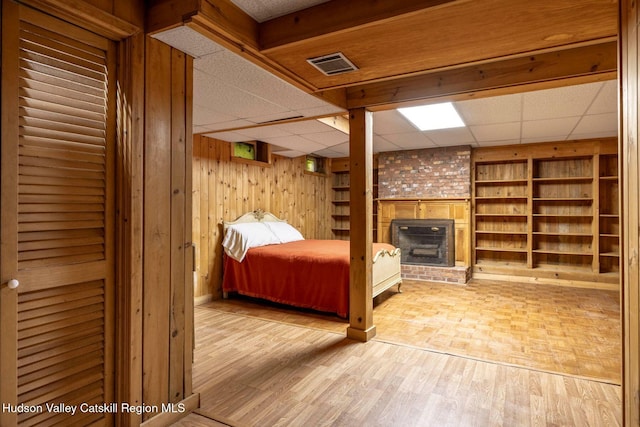 340 Lower Cady Rd, Old Chatham, NY 12136 - bedroom featuring a paneled ceiling, wooden walls, a fireplace, and wood finished floors