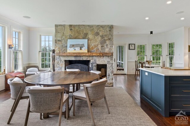 470 Harrington Dr, Austerlitz, NY 12017 - dining area featuring a stone fireplace, dark wood finished floors, ornamental molding, and wainscoting