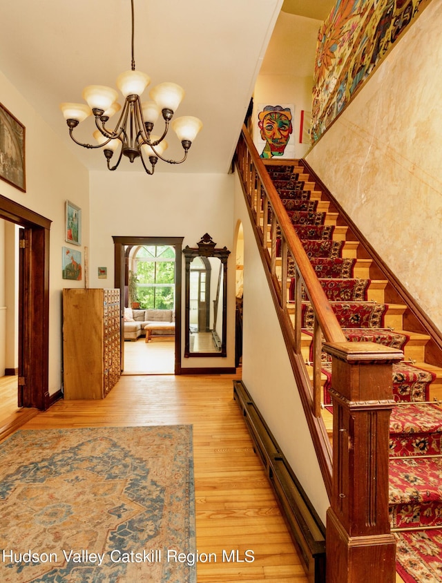 staircase featuring hardwood / wood-style floors and a chandelier