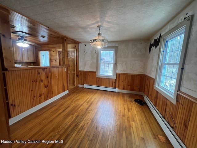 unfurnished dining area featuring a baseboard radiator and a healthy amount of sunlight