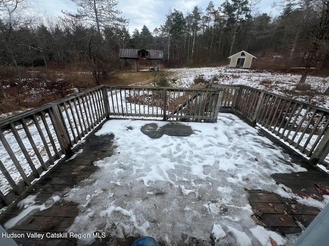 snow covered deck featuring a storage shed