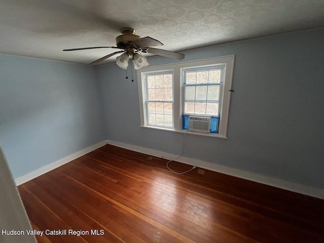 spare room featuring dark hardwood / wood-style floors, cooling unit, and ceiling fan