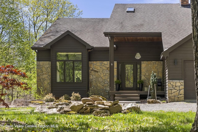 exterior space with a shingled roof and stone siding