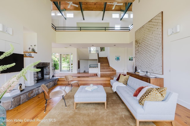 1114 County Route 3, Ancram, NY 12502 - living area with a high ceiling, a wood ceiling with exposed beams, stairs, wood finished floors, and a fireplace