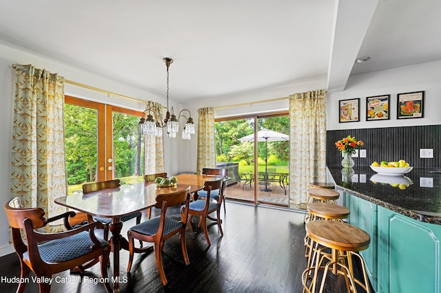 dining space featuring french doors, dark hardwood / wood-style floors, an inviting chandelier, and a healthy amount of sunlight