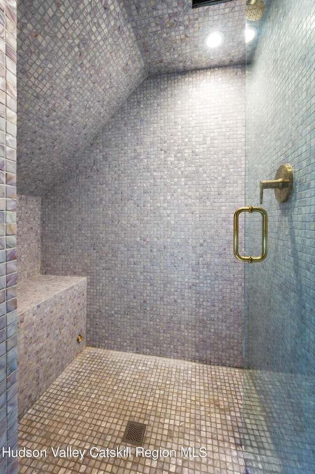 bathroom with an enclosed shower and lofted ceiling
