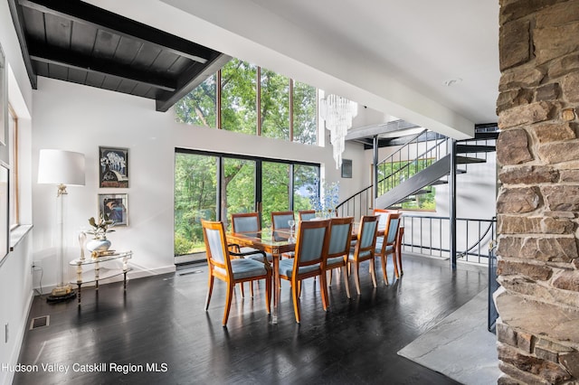 dining room featuring beam ceiling, high vaulted ceiling, dark wood-type flooring, and wood ceiling