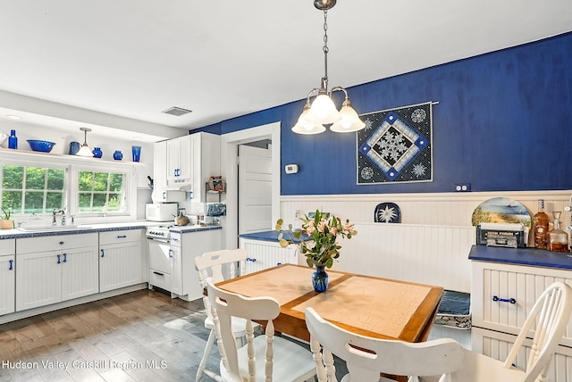 125 Bedell Rd, Poughkeepsie Town, NY 12603 - dining room with wood finished floors, wainscoting, and a chandelier