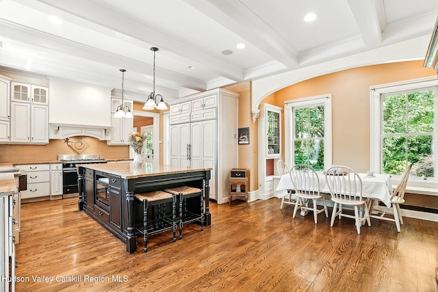 125 Bedell Rd, Poughkeepsie Town, NY 12603 - kitchen featuring appliances with stainless steel finishes, white cabinets, beamed ceiling, arched walkways, and a center island