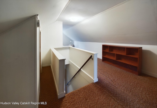 bonus room with dark colored carpet and lofted ceiling