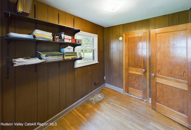 doorway to outside with wood walls and light hardwood / wood-style flooring