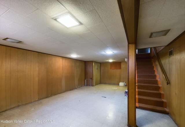 basement featuring wooden walls