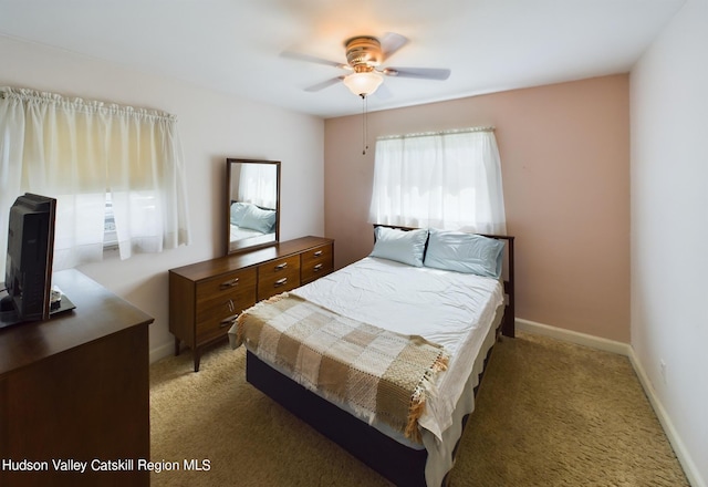 bedroom with ceiling fan and dark carpet