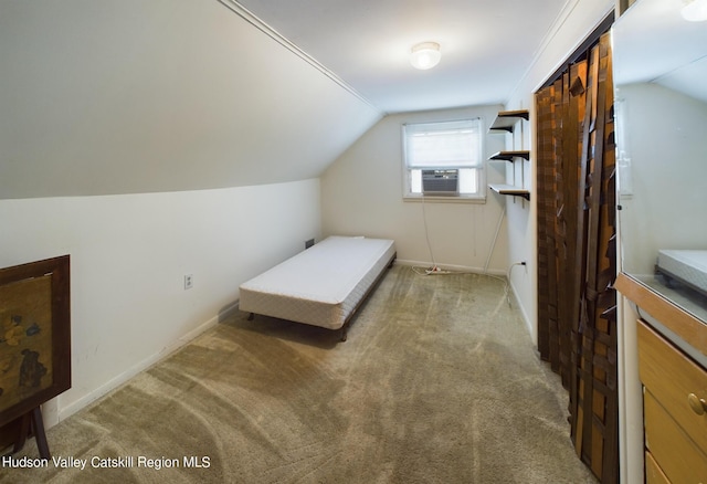 carpeted bedroom with cooling unit, a closet, and vaulted ceiling