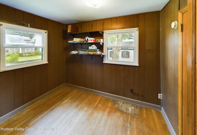 empty room with wood-type flooring and wood walls